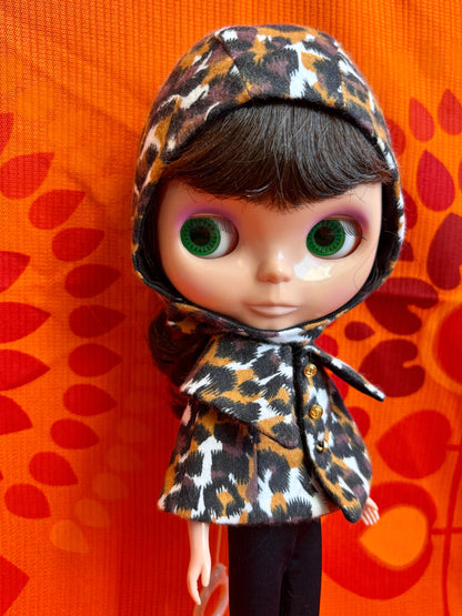 Doll wearing a leopard print outfit against an orange background